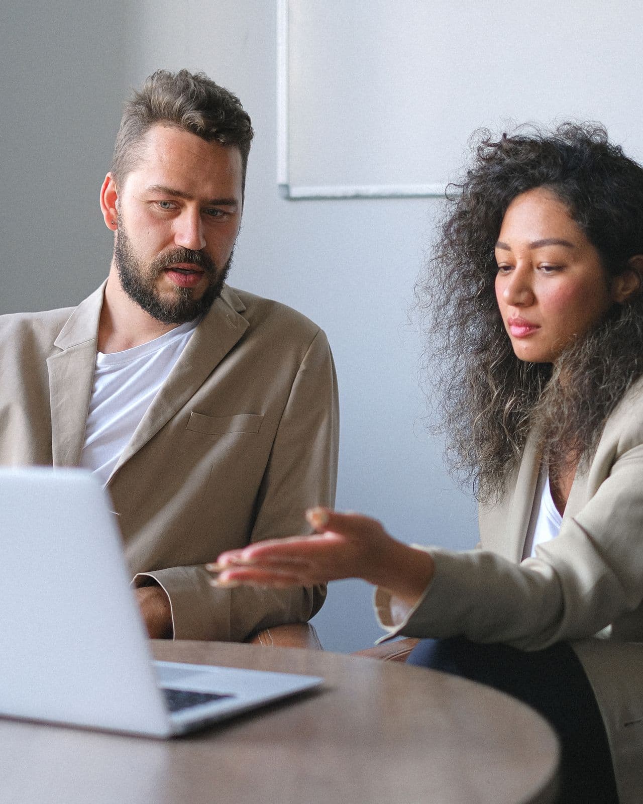 Two colleagues talking through a shortlist at a shared desk