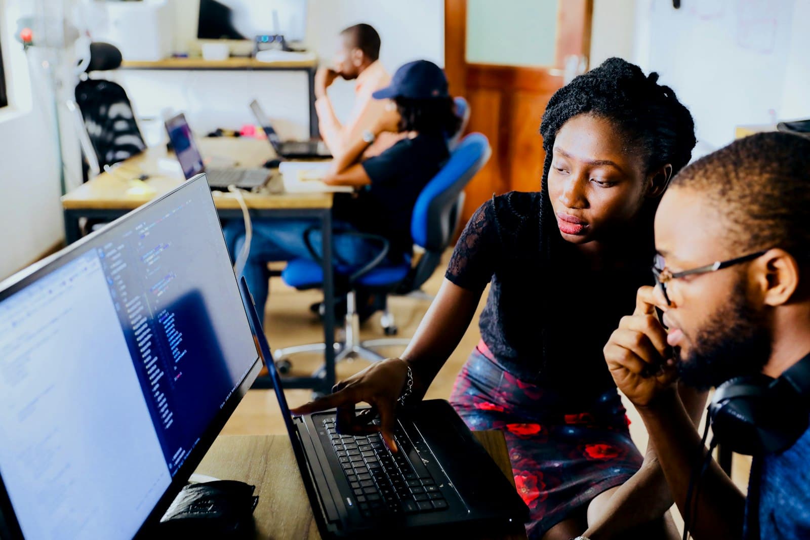 Two recruiters reviewing candidate search results on a monitor